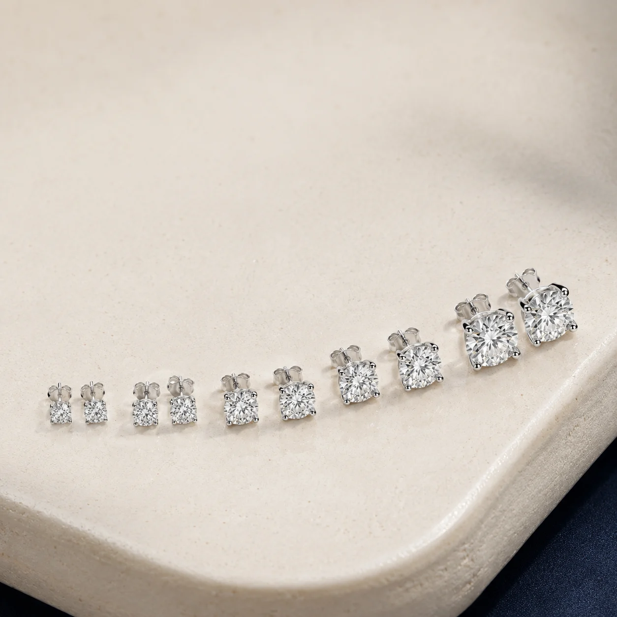 Platinum stud earrings arranged from delicate to statement sizes