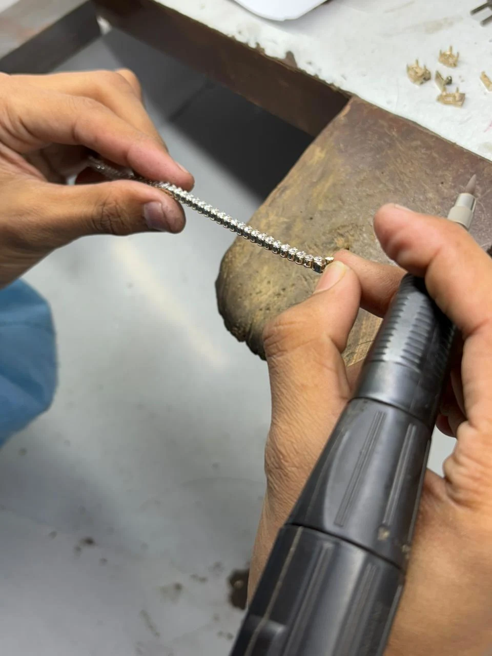 A jeweller setting stones into a platinum piece at the workbench